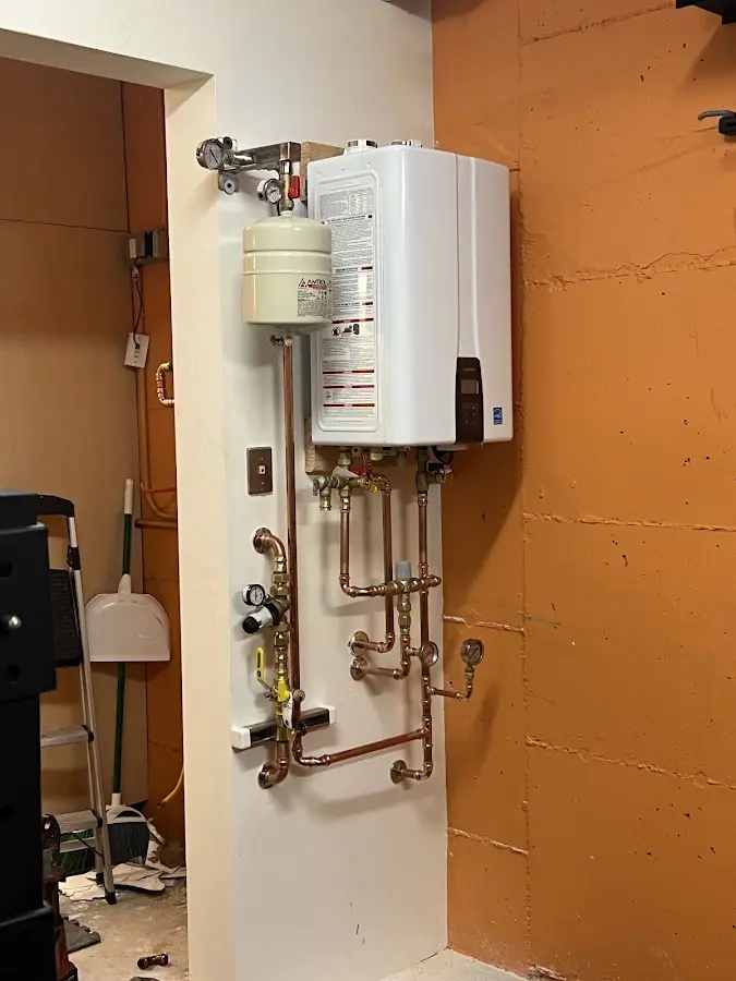 Plumbing technician inspecting water heater connections in Florence